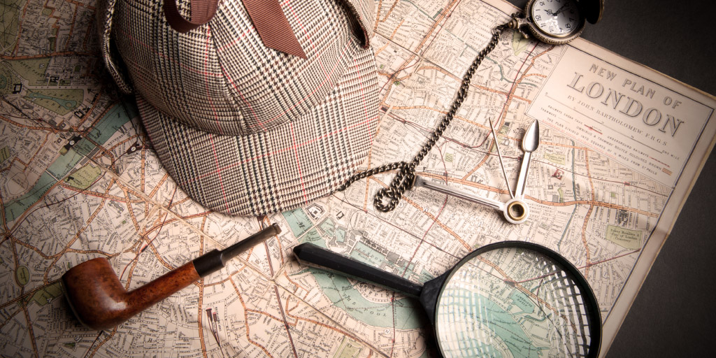 Sherlock Holmes hat, pipe, and magnifying glass on London map