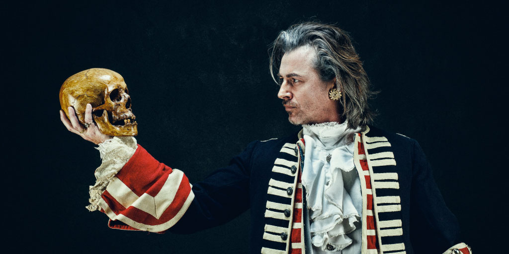 Hamlet in classical dress  looking at a skull in his hand