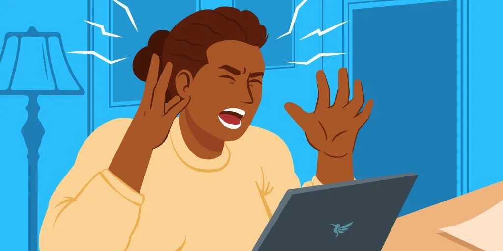 A woman sitting screaming in angry pose in front of a notebook computer